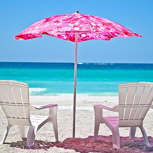 Chairs by the beach with pink umbrella image
