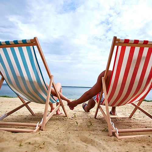 Photo of two people sitting in chairs on the beach